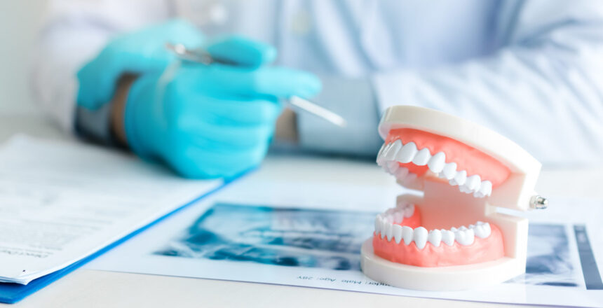 Close up dentures with dentist working on table in clinic.